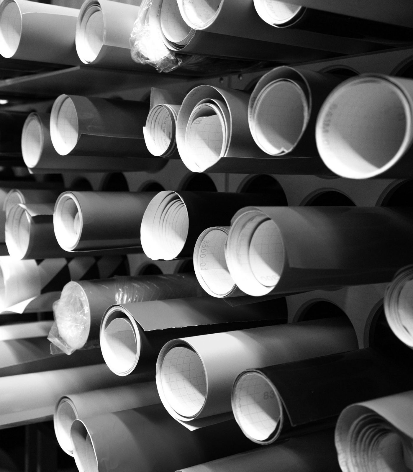Vinyl film of different colors in round tubes. Advertising production. A store selling self-adhesive films.